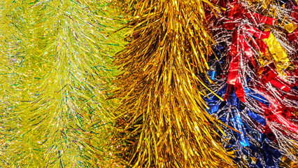 christmas festive background of decorative colorful foil garlands close up shallow depth of field