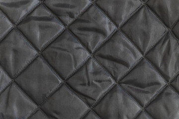 abstract background of dark grey silk quilted fabric texture close up