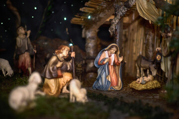 Fototapeta premium A Christmas manger scene with beautifully carved figures, including baby Jesus, Mary, Joseph, shepherds and animals. Emotions visible on the characters' faces.