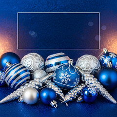 Festive blue and silver christmas ornaments on a shimmering blue background