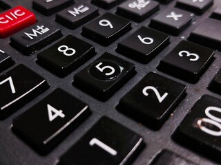 Close-up of black calculator keypad with numeric buttons, highlighting finance, accounting, budgeting, and office work details.