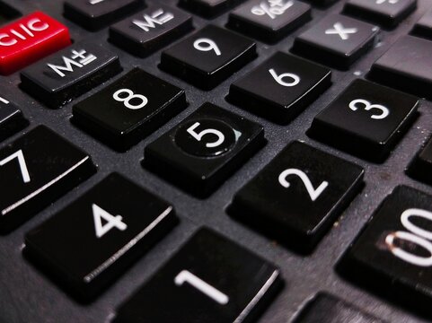 Close-up of black calculator keypad with numeric buttons, highlighting finance, accounting, budgeting, and office work details.
