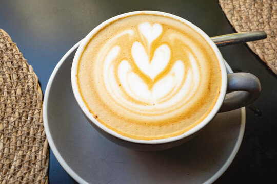 Speciality coffee beverage presenting beautiful heart latte art in a white ceramic cup - Powered by Adobe