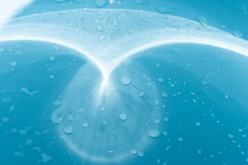 Blue water with ripples on the surface. Defocus blurred transparent blue colored clear calm water surface texture with splashes and bubbles. Water waves with shining pattern texture background.