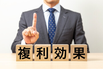 「複利効果」と書かれたブロックとビジネスマン