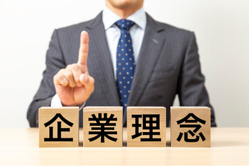 「企業理念」と書かれたブロックとビジネスマン