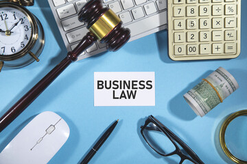 Business Law on business card with a judge gavel and business objects.