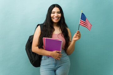 Hispanic student holding usa flag celebrating patriotism and education