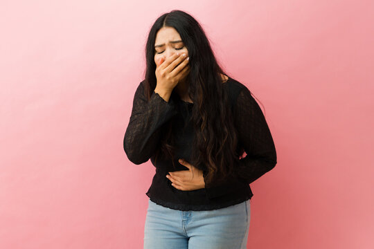 Young woman feeling nauseous from upset stomach