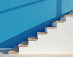 White staircase with stone steps ascends diagonally against blue wall. Shadow falls on wall and floor. Clean minimalist architecture. Modern building interior or exterior design.