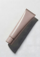 A close-up studio shot of a light brown cosmetic tube casting a shadow on a white surface.