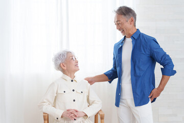 部屋にいる笑顔のシニア夫婦