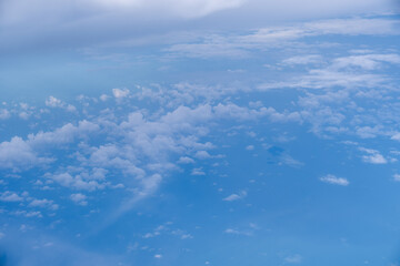 A breathtaking view of the blue sky and fluffy white clouds seen from high above the atmosphere, creating a serene and expansive scene.