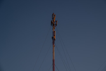 5G communication tower with clear blue sky background