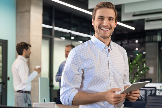 Handsome businessman using his tablet in the office.