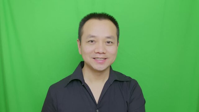 Asian man smiled at the camera friendly, nodded friendly, gestured to the camera, nodded in affirmation, nodded as a greeting, vertical portrait video.