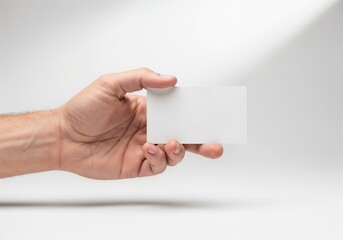 Hand holding a blank card with soft lighting against a simple background