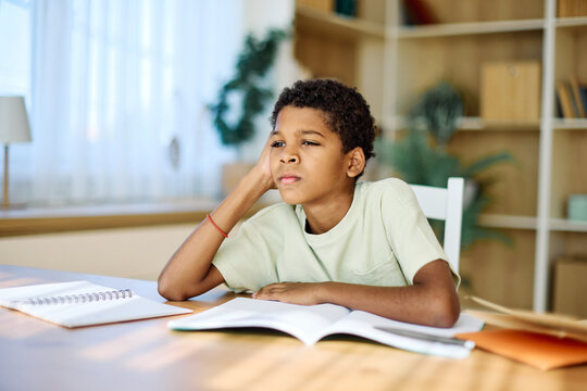 Portrait of a teenage boy having fun writing and doing homework at home