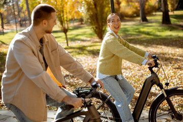 Joyful bike ride between friends in a colorful autumn park