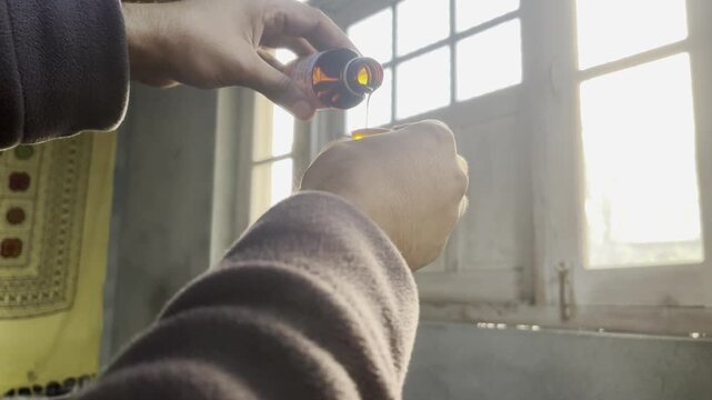 An ill or sick man having cough influenza and fever which is common in winter taking medicine and cough syrup to get rid of common cold and fever. Closeup footage of man taking medicine at home 