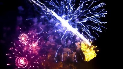 Spectacular night sky illuminated by vibrant bursts of colorful fireworks, creating a dazzling display of light and celebration