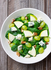Salad with spinach, blue cheese, pear, grapes, and nuts. Healthy eating. Vegetarian.