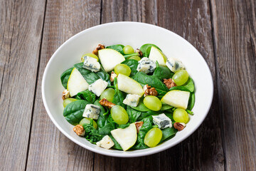 Salad with spinach, blue cheese, pear, grapes, and nuts. Healthy eating. Vegetarian.