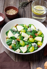 Salad with spinach, blue cheese, pear, grapes, and nuts. Healthy eating. Vegetarian.