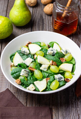 Salad with spinach, blue cheese, pear, grapes, and nuts. Healthy eating. Vegetarian.