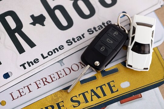 Remote control car keys on US license plates with state names close up. Concept of driving in United States. Reaching a driving license
