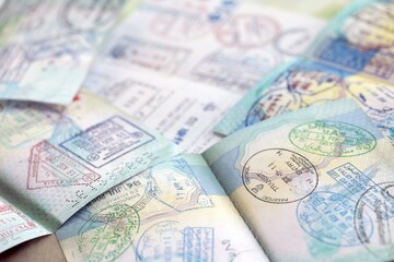 Many open passport pages with lots of visas and entrance stamps from various countries passport...