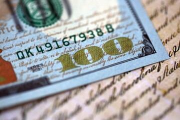 One hundred US dollar bills and United States Constitution page fragment. Concept of lawsuit and...