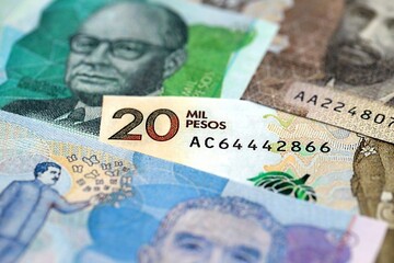 Colombian pesos money bills banknotes lies in big pile on table close up. Concept of finances and...