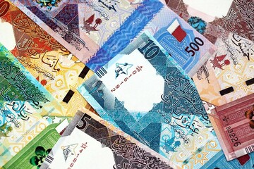 Qatari riyal money bills banknotes lies in big pile on table close up. Concept of finances and...
