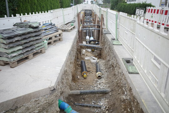 Open Trench Construction Site with Pipes and Barriers