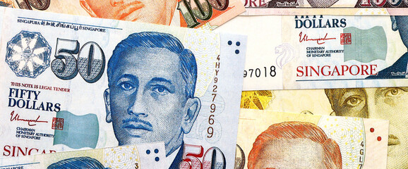 Singapore Dollar currency money bills. SGD currency banknotes in pile with different denomination...