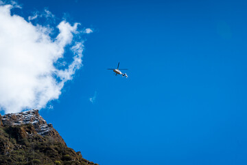 White Helicopter Against a Backdrop of Deep Blue Sky and Cloud
