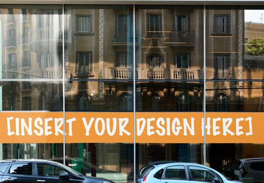 A mockup displays a Storefront signage in modern building with reflections on glass windows in Barcelona