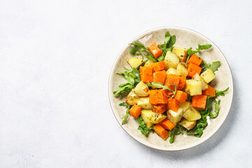 Warm salad with pumpkin, potato and arugula.