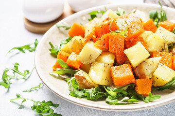 Warm salad with pumpkin, potato and arugula.