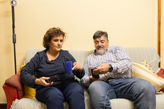 Couple using digital devices at home ignoring each other
