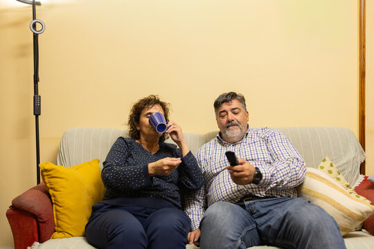 Mature couple relaxing on sofa watching tv