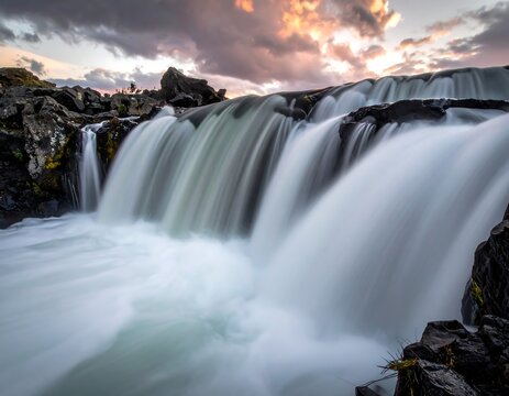 Long exposure captures flowing water cascading over rocks at sunset - Powered by Adobe