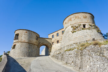 Massive stone fortress Castello Due Torri (Torriana) on a hilltop with two circular bastions.