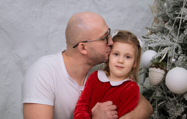 father and daughter happily playing and having fun near the Christmas tree