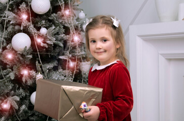 a little girl holds a Christmas gift box
