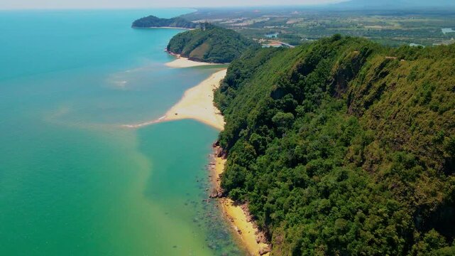 Aerial view of Pantai Bukit Keluang, Besut, Terengganu, showing turquoise waters, coastal cliffs, and clear sunny skies along the scenic shoreline.