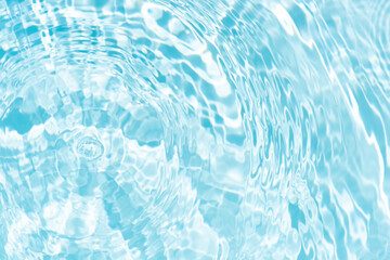 Blue water with ripples on the surface. Defocus blurred transparent blue colored clear calm water surface texture with splashes and bubbles. Water waves with shining pattern texture background.