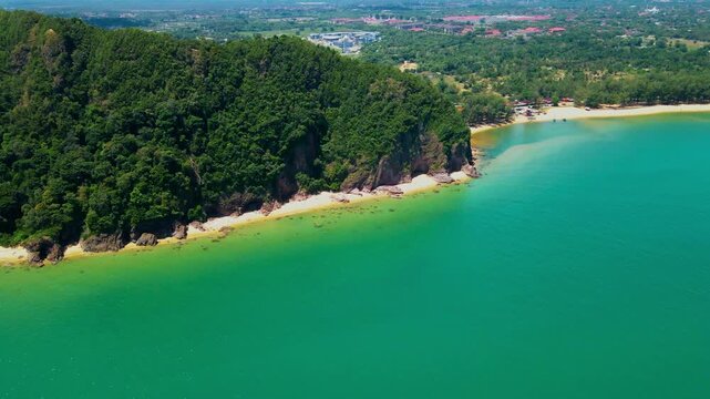 Aerial view of Pantai Bukit Keluang, Besut, Terengganu, showing turquoise waters, coastal cliffs, and clear sunny skies along the scenic shoreline.