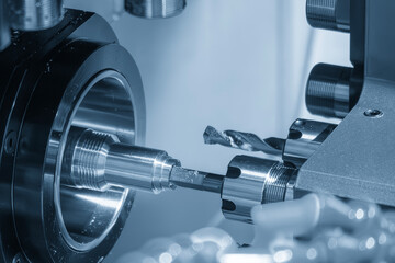 Close up scene multi-tasking CNC lathe machine swiss type hole drilling process the brass coupling parts in the light blue scene.